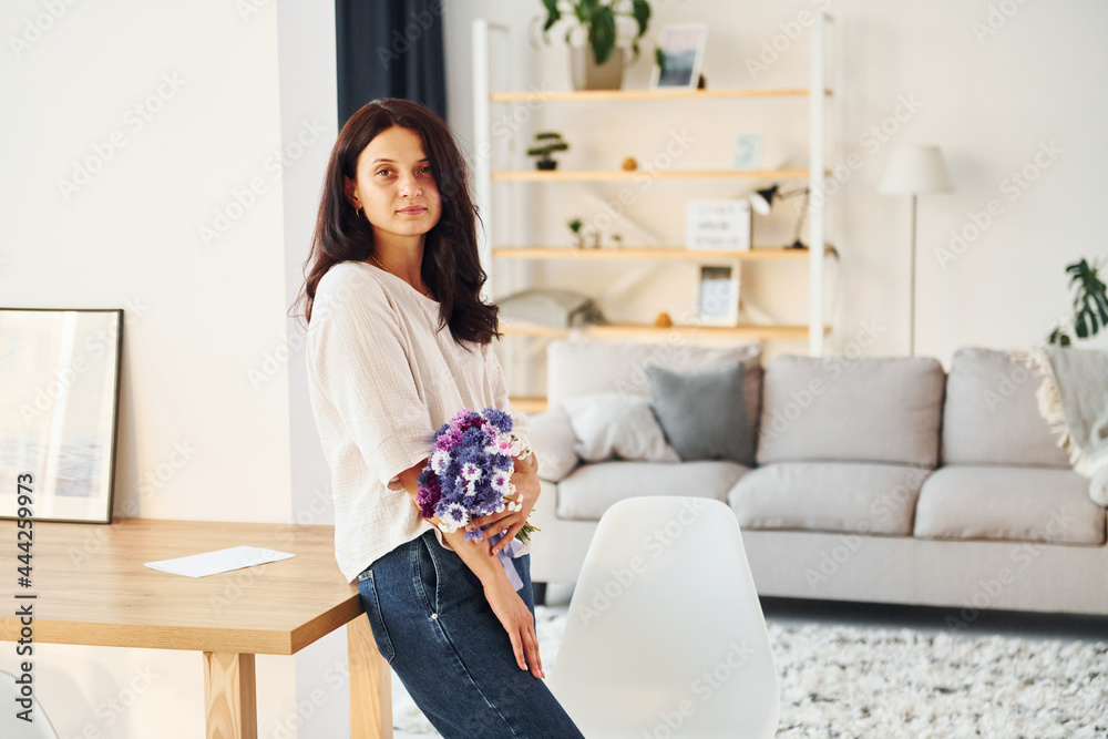 Young woman is at home alone. Modern design and interior Young woman is at home alone. Modern design and interior