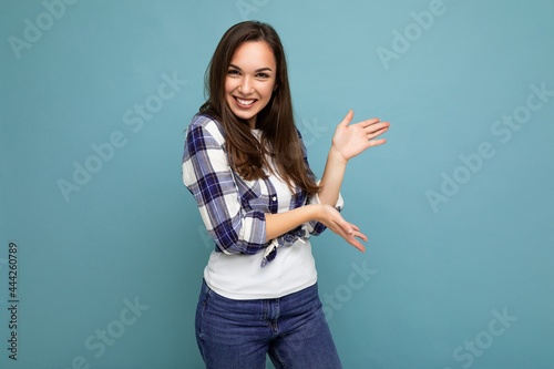 Close up photo of positive happy amazing cute nice charming young woman holding hands and showing advertisement wearing casual clothes isolated over background with copy space