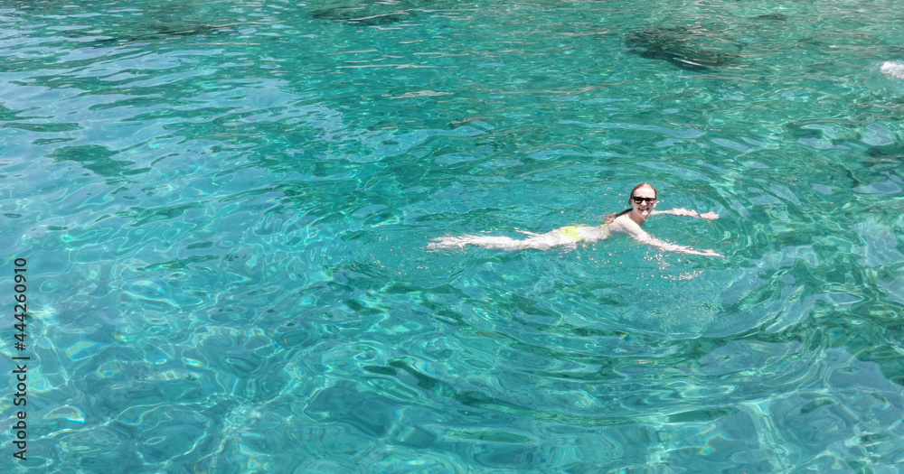 A young girl in a bikini swims on the Cote d'Azur. The Aegean sea. Turkey, Kusadasi.