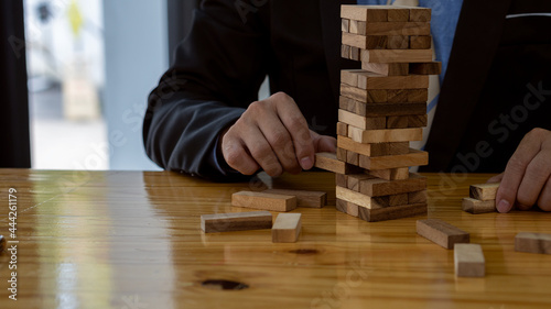 Plans and alternative risk strategies in business The risk of creating a growth concept of a businessman's hands pulling a wooden block on a table.