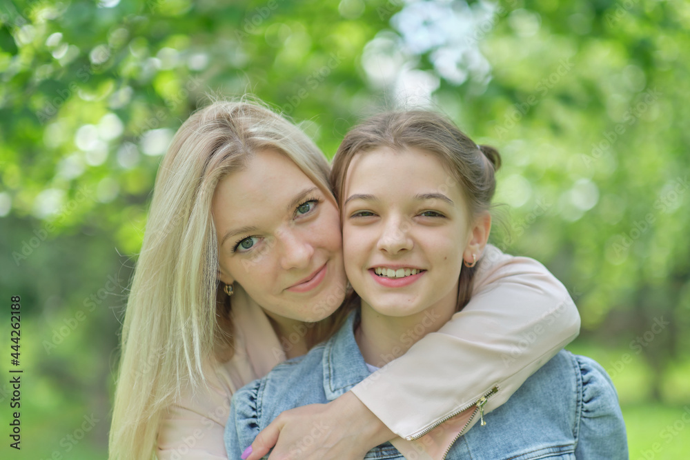 happy mother with her daughter hugging a teenager in the summer. Caring happy mother enjoy day with teenage girl child, laugh have fun. Mother giving her daughter advice.