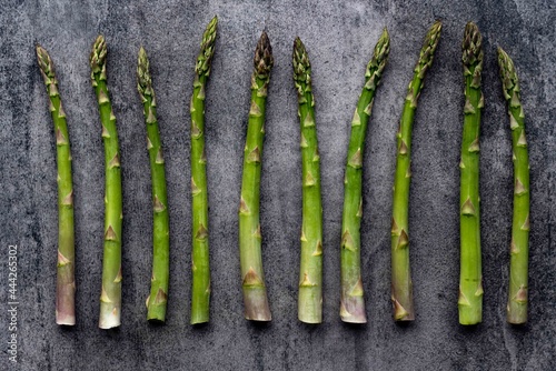Green fresh raw asparagus on concrete background.Bunch of fresh asparagus top view on gray concrete background