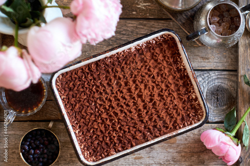 Homemade tiramisu. Peonies, coffee, blueberries. Wooden background. Top view. photo