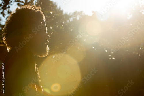 horizontal background of man in profile with len- horizontal lens flare men portrait photo
