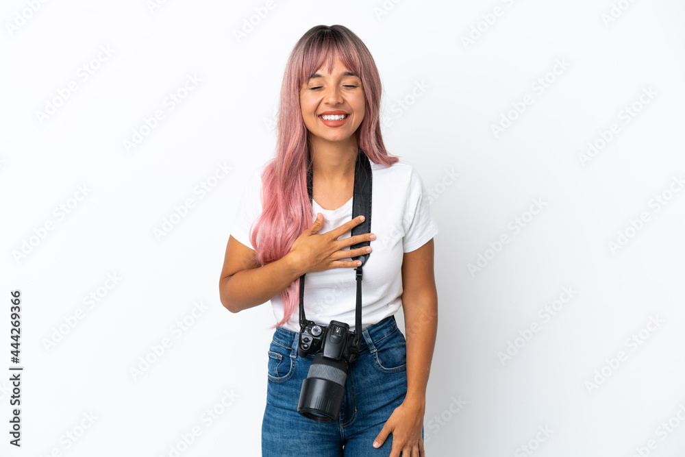 Young photographer mixed race woman with pink hair isolated on white background smiling a lot Young photographer mixed race woman with pink hair isolated on white background smiling a lot