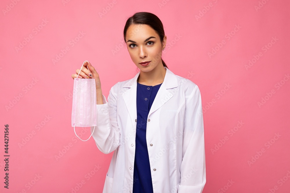 Caucasian woman showing protection face mask isolated on pink background. Coronavirus or Covid-19 Concept Caucasian woman showing protection face mask isolated on pink background. Coronavirus or Covid-19 Concept