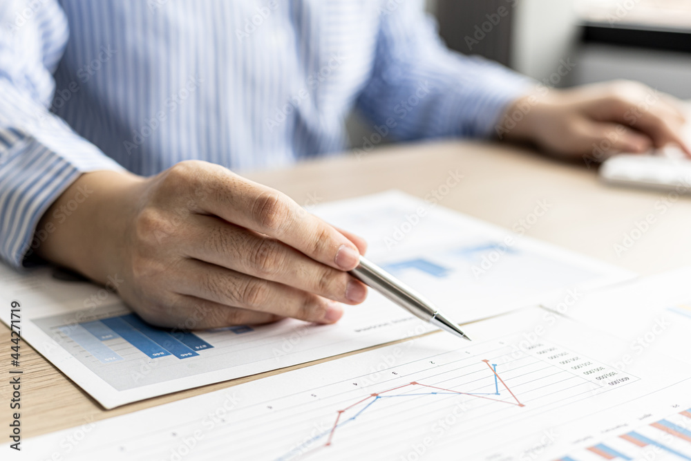 The businesswoman points to the company financial summary prepared by the finance department, she is checking the accuracy of the monthly financial statements. Concept of company financial management. The businesswoman points to the company financial summary prepared by the finance department, she is checking the accuracy of the monthly financial statements. Concept of company financial management.