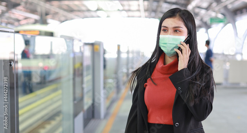 New normal covid-19 epidemic  young business asian woman wearing mask protection for prevent virus covid-19 or coronavirus infection from people in train  using smartphone communication in train