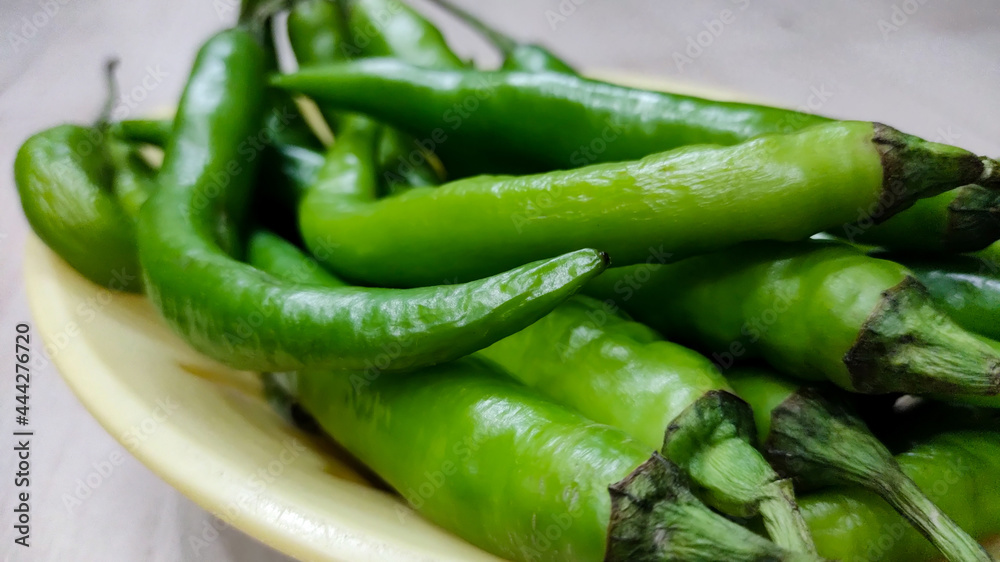 Green peppers in the threshing basket on wooden table Green peppers in the threshing basket on wooden table