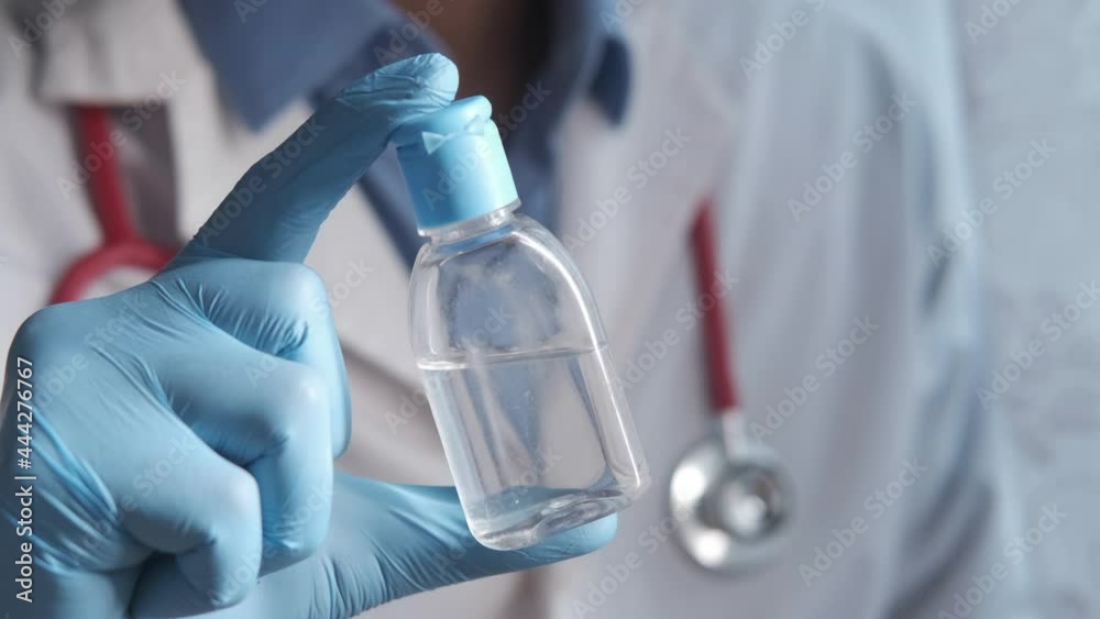 close up of doctor hand holding hand sanitizer close up of doctor hand holding hand sanitizer