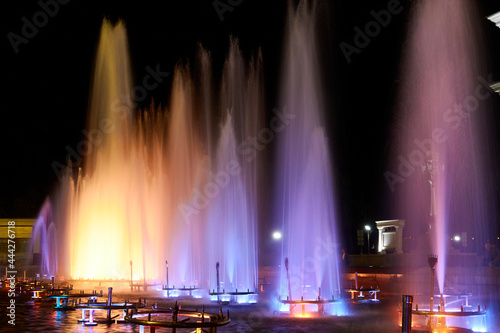 city fountain illuminated with green and yellow lights at night