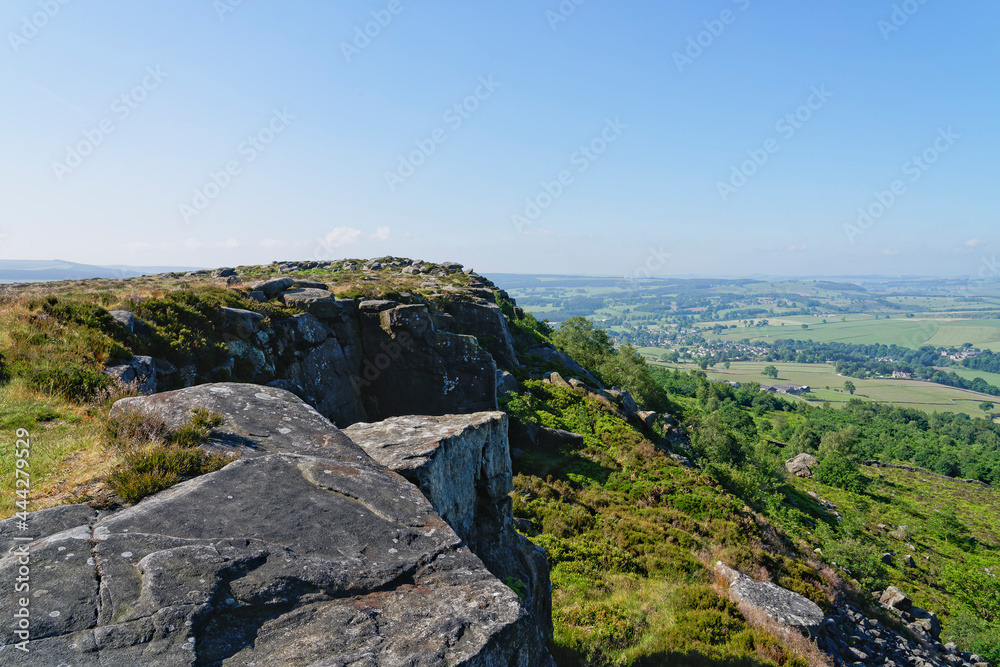 Multi coloured gritstone forms the cliff face of Baslow Edge, Derbyshire