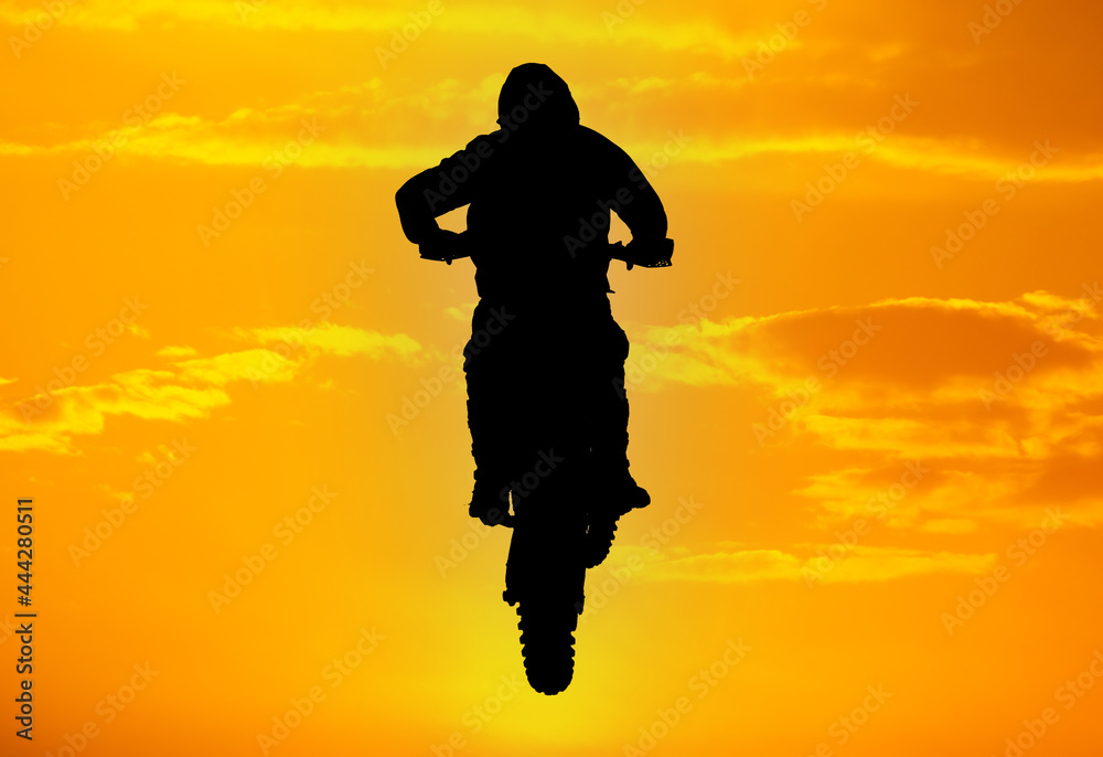 Silhouette of a man on a motorcycle against the background of a golden