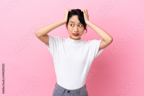 Young Vietnamese woman isolated on pink background doing nervous gesture
