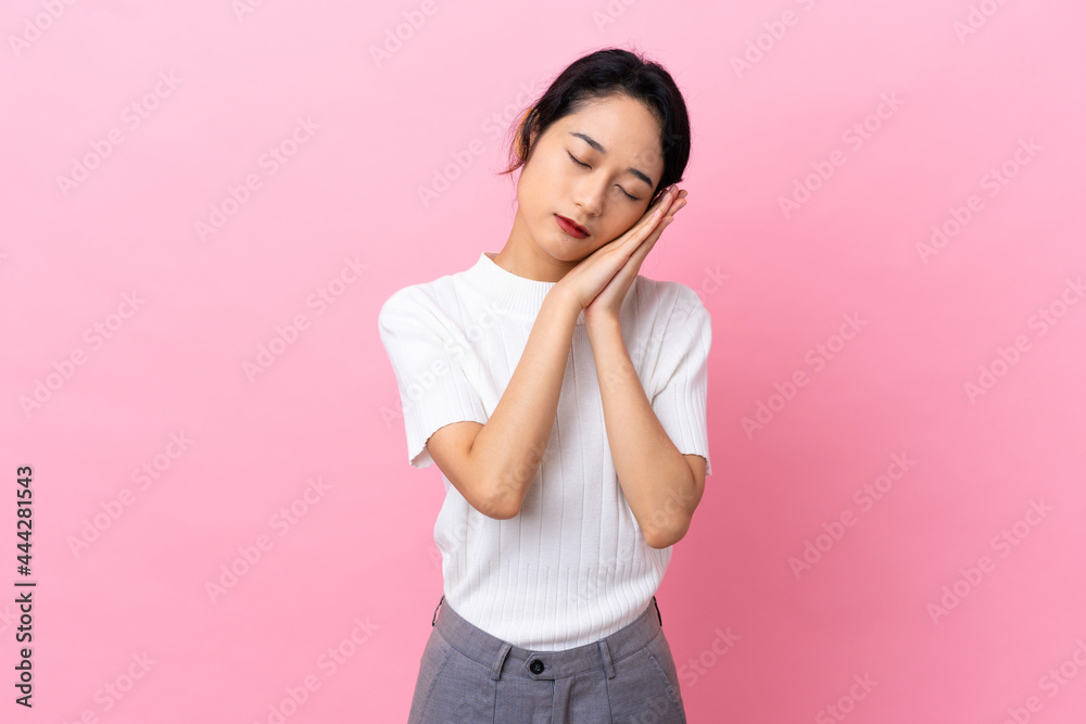 Young Vietnamese woman isolated on pink background making sleep gesture in dorable expression Young Vietnamese woman isolated on pink background making sleep gesture in dorable expression