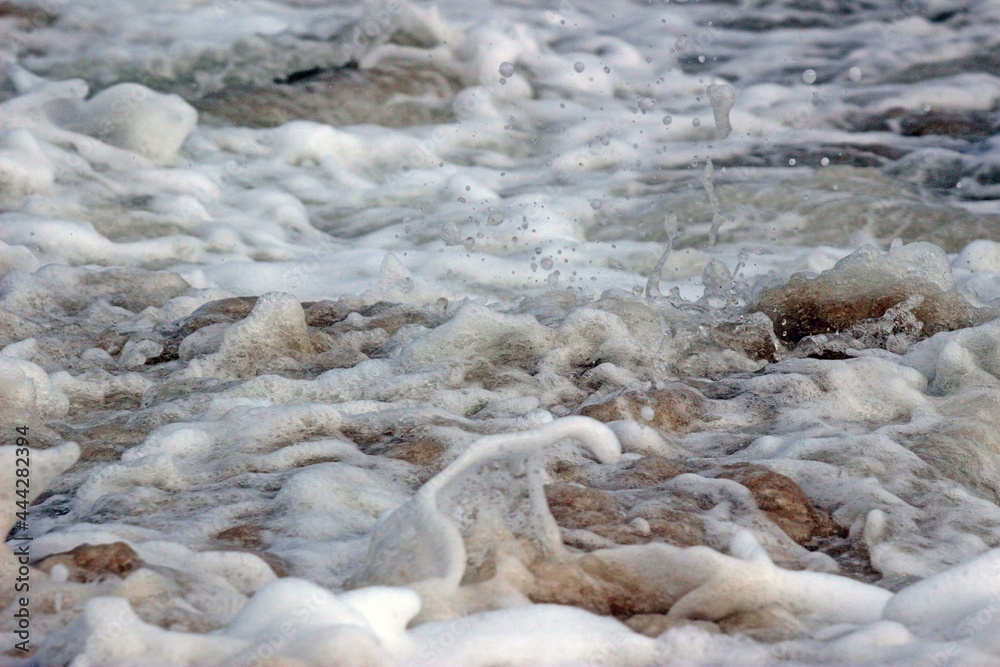 Close-up macro detail of choppy white ocean water frothing and splashing creating a rough natural texture Close-up macro detail of choppy white ocean water frothing and splashing creating a rough natural texture