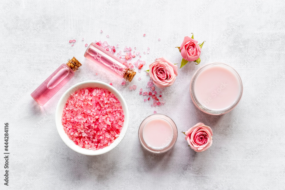 Cosmetics with rose oil essence. Face cream lotion and flowers, top view Cosmetics with rose oil essence. Face cream lotion and flowers, top view