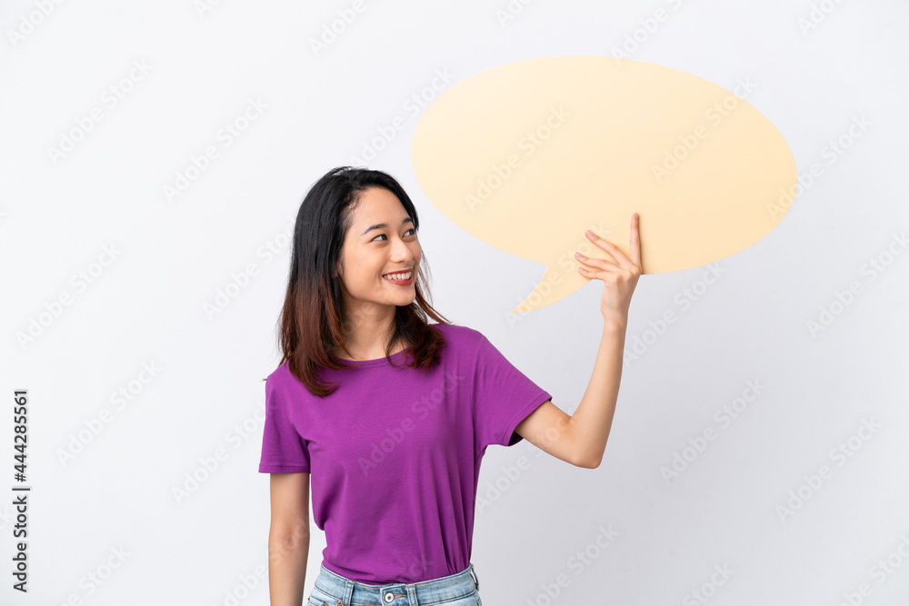 Young Vietnamese woman isolated on white background holding an empty speech bubble Young Vietnamese woman isolated on white background holding an empty speech bubble