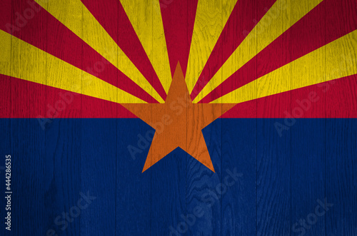 The flag of Arizona on a grunge wooden background.