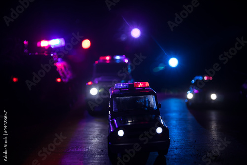Police cars at night. Police car chasing a car at night with fog background. 911 Emergency response police car speeding to scene of crime.