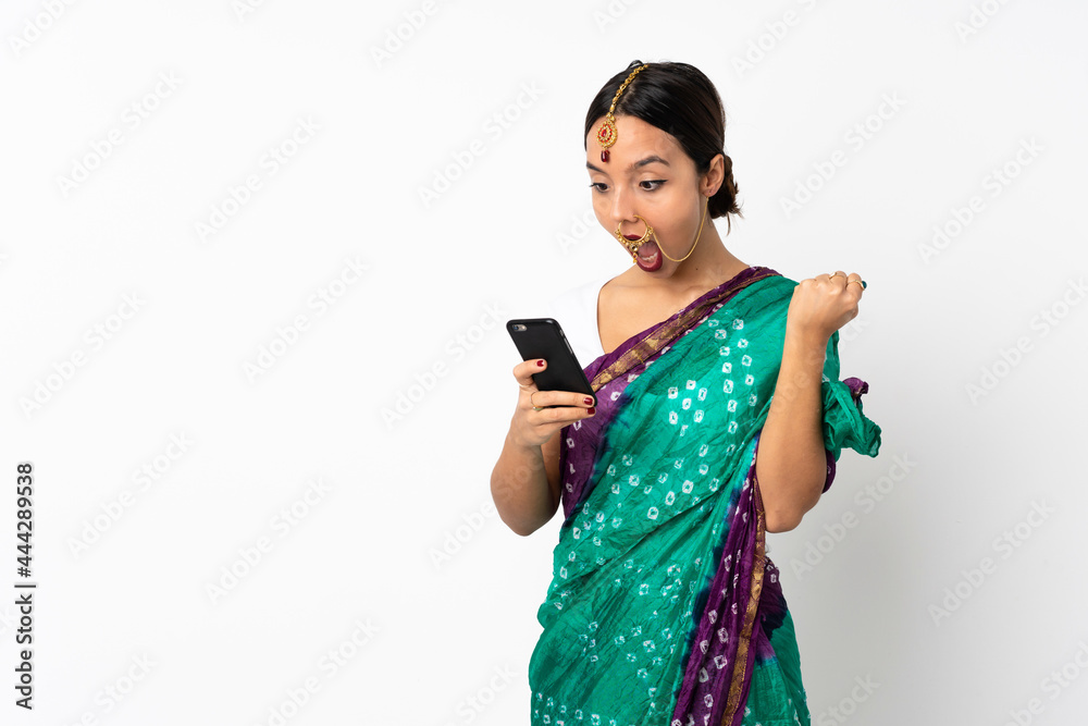 Young indian woman isolated on white background surprised and sending a message Young indian woman isolated on white background surprised and sending a message