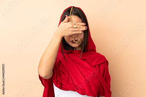 Canvas Print Young Indian woman isolated on beige background covering eyes by hands