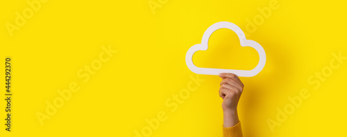 Cloud computing concept, hand holding cloud over yellow background, cloud storage, panoramic mock-up