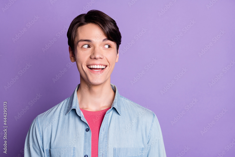 Photo of young excited guy happy positive smile curious dream look empty space isolated over violet color background Photo of young excited guy happy positive smile curious dream look empty space isolated over violet color background