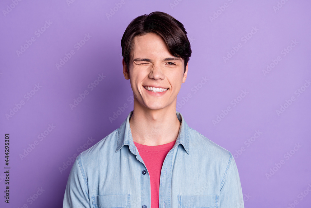 Photo of young cheerful guy happy positive smile wink eye funky isolated over violet color background
