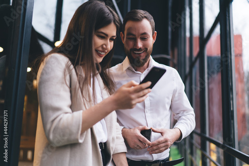 Photography Positive colleagues surfing smartphone together
