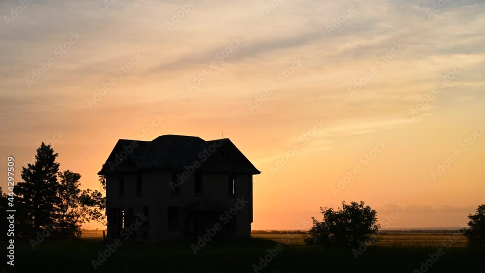 Sunset clouds moving with an abandoned house silhouette in the foreground. The sunset can be seen through the empty windows in the house.
Sunset clouds moving with an abandoned house silhouette in the foreground. The sunset can be seen through the empty windows in the house.
