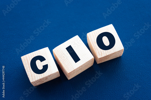 CIO written on wooden cubes - arranged in a vertical pyramid, grey and blue background, CIO - short for Chief Information Investment Officer, business concept