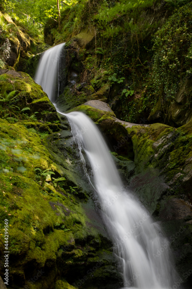 a large welsh waterfall flowing down the side of a cliff