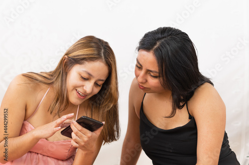 Young women checking the cell phone looking for pictures on the internet.