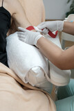 Close up of patient's hand tightened with tourniquet before taking a dropper blood sample. Nurse or doctor preparing a woman before the venipuncture procedure