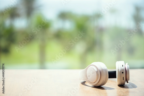 Headphones on the table in the palm tree forest. Summer vocation. Listen music. Concept