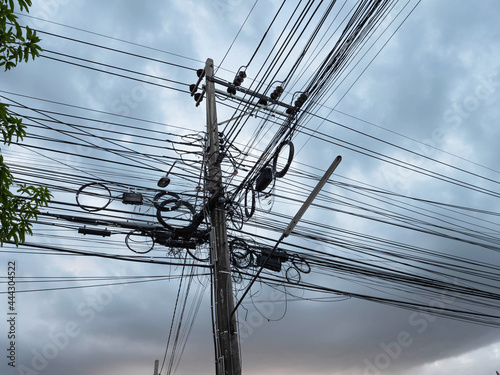 Communication system cables and electric cables on pole with cloudy on sky.