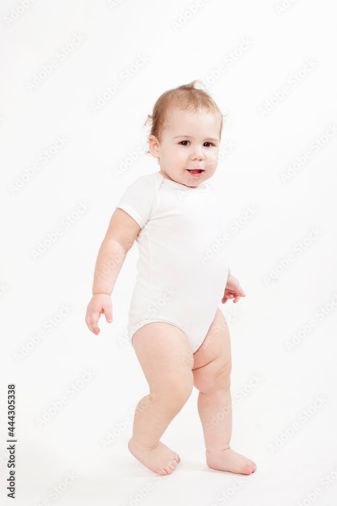 beautiful baby dressed in white walking on a white background beautiful baby dressed in white walking on a white background