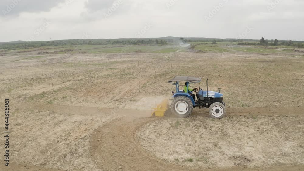 Malaysia, June 07, 2020 : A farmer on a tractor plows the field for further sowing of the crop. Soil preparation. Working with a plow. Growing durian Malaysia, June 07, 2020 : A farmer on a tractor plows the field for further sowing of the crop. Soil preparation. Working with a plow. Growing durian