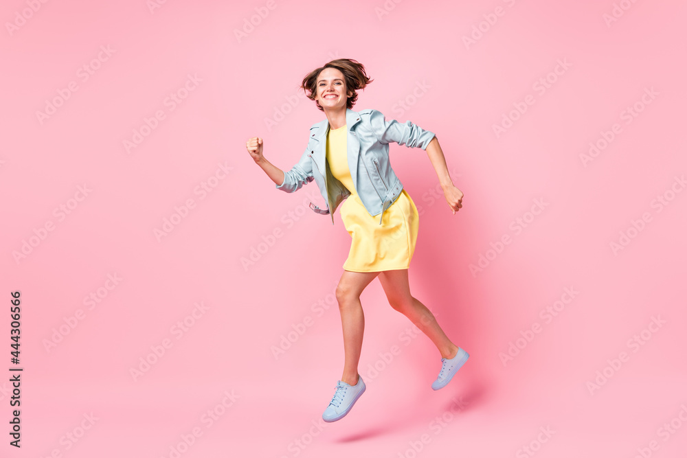 Full size profile side photo of young beautiful happy cheerful positive girl running in air isolated on pink color background Full size profile side photo of young beautiful happy cheerful positive girl running in air isolated on pink color background