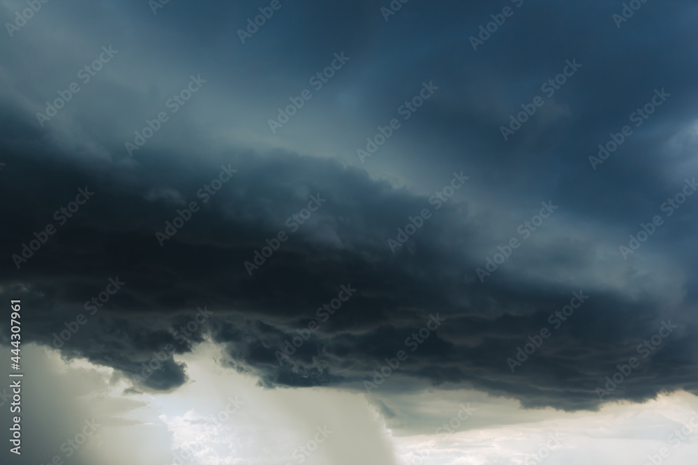 The dark sky with heavy clouds converging and a violent storm before the rain.Bad or moody weather sky and environment. carbon dioxide emissions, greenhouse effect, global warming, climate change.