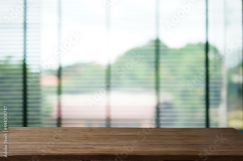 Abstract bokeh sunlight view from the window background with old wood table.	