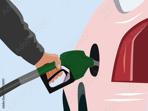 close up of arm is holding the fuel nozzle to fill the gas station with blue background