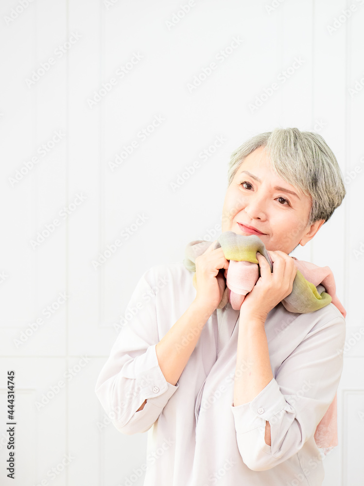 Senior beautiful grey-haired asian woman wearing casual dress and silk scarf.