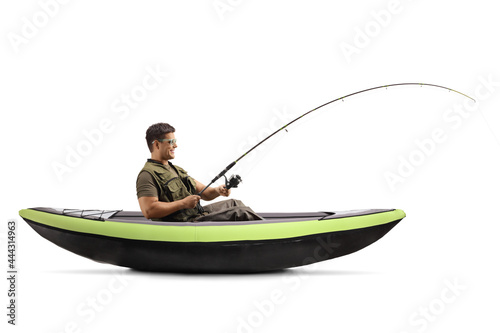 Side shot of a young man catching fish from a canoe