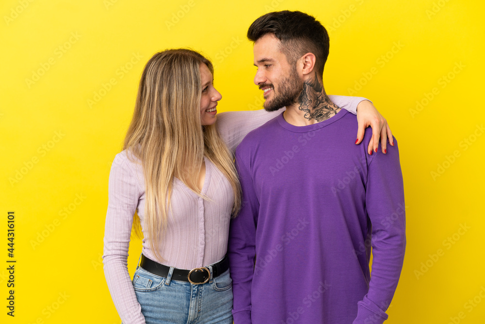 Obraz premium Young couple over isolated yellow background happy and laughing