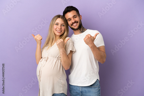 Young couple pregnant and with thumb up