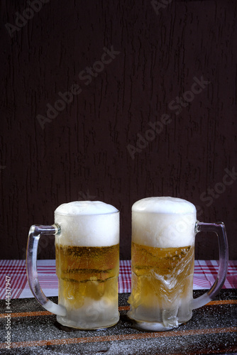 delicious mug of super cold and refreshing draft beer on the table in the blurred background photo