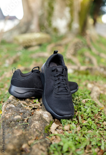 Black tennis shoes on a grass © Carlos