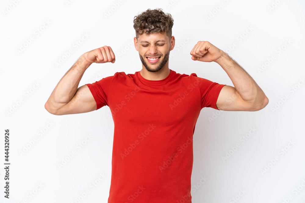 Young caucasian handsome man isolated on white background doing strong gesture Young caucasian handsome man isolated on white background doing strong gesture
